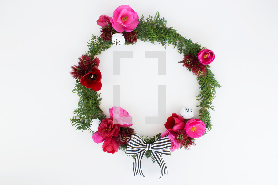 flowers and pine with bow on Christmas wreath 