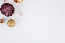 pink, purple, and gold Christmas ornaments on white 