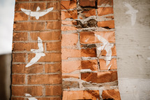 doves painted on a brick wall 