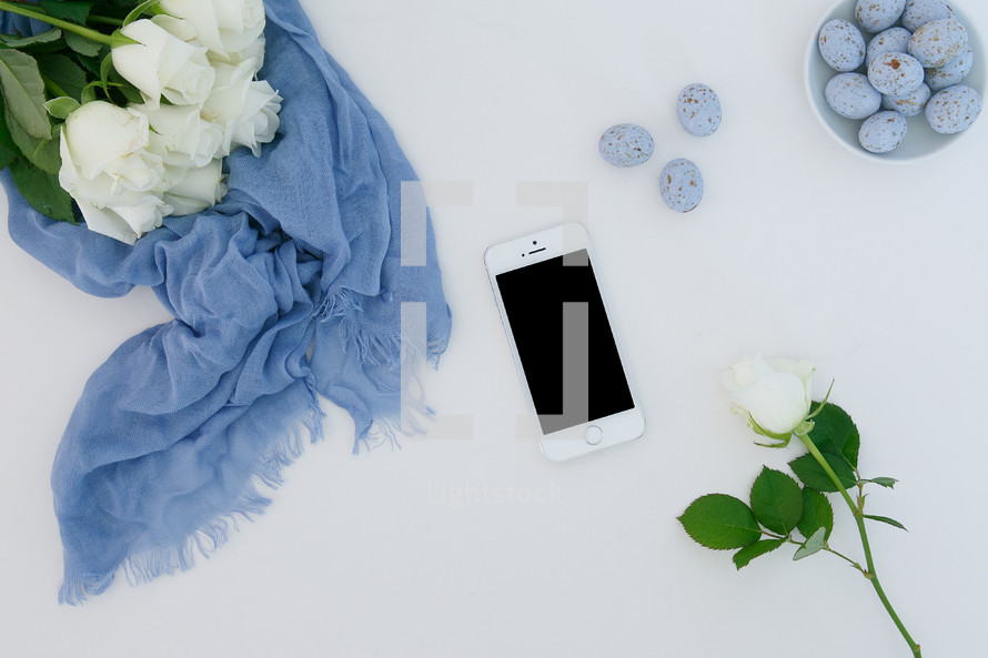 white roses, blue scarf, speckled blue eggs, white background, iPhone 