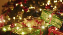 Illuminated Christmas gift box under the tree on the carpet