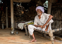 a man sitting on a cot in India 