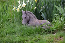 Horse Statue in a flower garden in spring time.