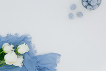 speckled blue eggs, blue scarf, and white roses 