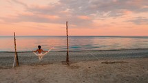 Girl on the Swing by the Calm Ocean at Sunset