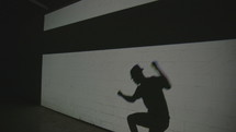 a man dancing in front of a projector 