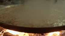 Celebrating Fallas in Valencia, Spain, they prepare chicken paella on a large traditional skillet