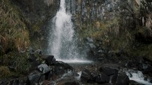 Waterfall Cascading Down Over River Rocks In Cayambe Coca National Park, Papallacta, Ecuador - tilt down