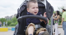 Toddler boy in stroller looking frantically for parents