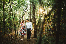 a happy couple standing in the woods 