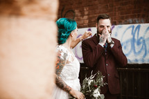 hipster bride and groom standing in an alley 