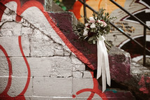bridal bouquet on graffiti covered steps 