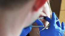 a dentist examining a woman's teeth 