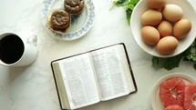 open Bible on a table with breakfast 