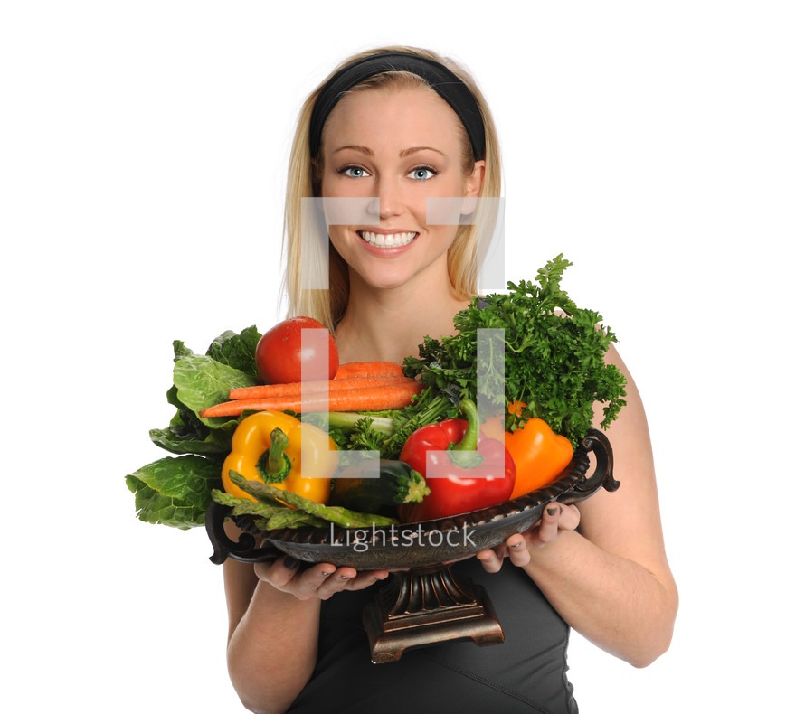 Woman holding a bowl of fresh vegetables.