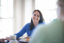 Smiling woman at the breakfast table.