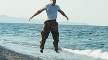 soldier does jump squats on the beach