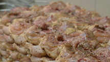Close up of seasoned raw chicken. 