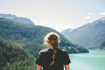 a woman with a braided ponytail standing with her back to the camera at Lake Diablo 