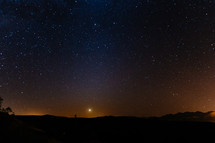 stars in the night sky above a horizon 