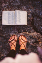 open Bible and feet in sandals