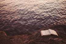 Bible open at the edge of a waterway