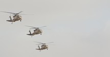 Three BlackHawk military helicopters flying in formation