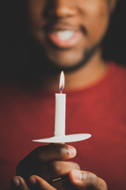 a man holding a candle at a Christmas Eve Service