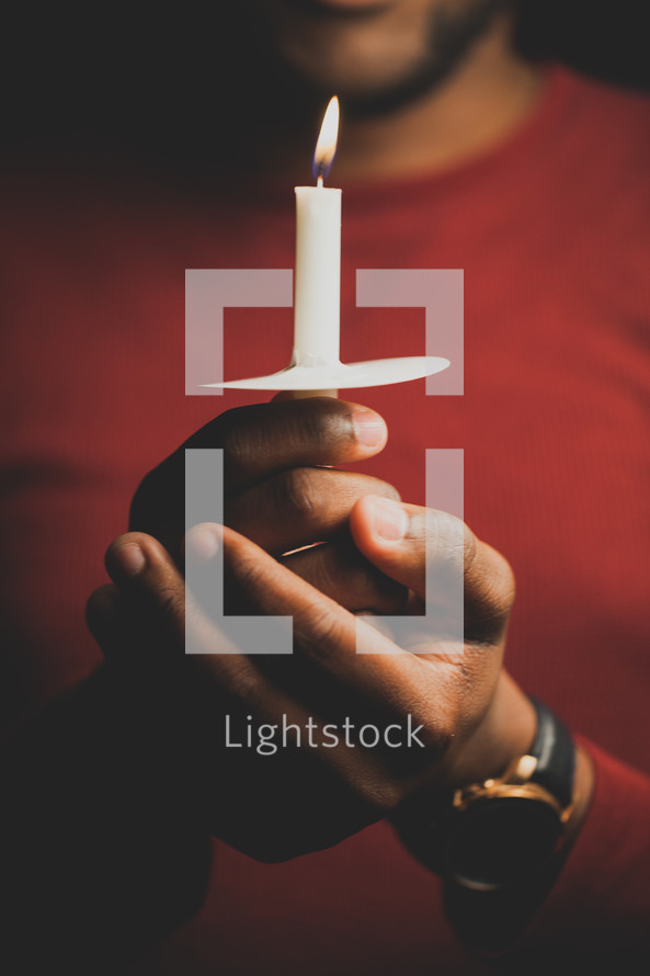 a man holding a candle at a Christmas Eve service 