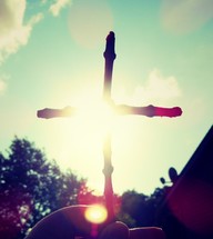 cross made of sticks in sunlight