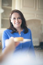 woman serving a donut on a plate