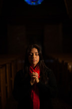 a woman praying in the aisle of a church 