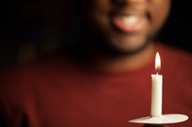 a man holding a candle at a Christmas Eve Service 