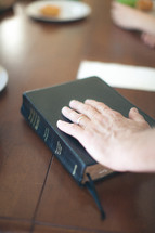 man's hand on a Bible 