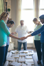 group holding hands in prayer at a Bible study