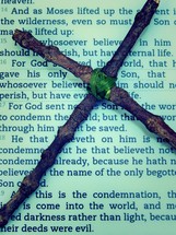 cross made of sticks on the pages of a Bible 