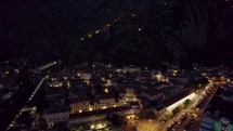 Night aerial view of medieval old town Kotor, Montenegro, mountain cliffs in background