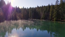 Crestasee Lake in Switzerland Reflecting the Forest in the Misty Emerald Waters