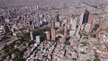 High angle drone shot circling the Bogota city skyline, sunny day in Colombia