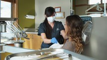 a dental hygienist and patient in a dental exam room 