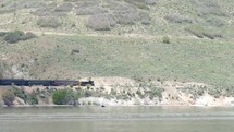train traveling alongside a lake shore 