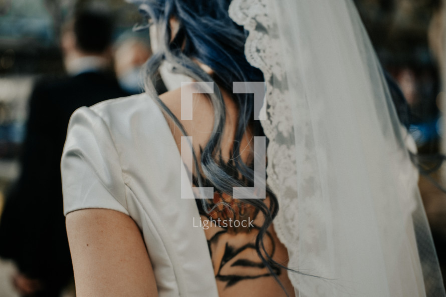 bride with a back tattoo in a city 