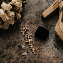 white roses, hair clips, and high heels for a bride 
