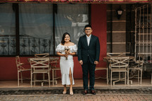 bride and groom standing in front of a restaurant 