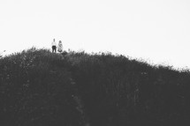 a couple standing on a hilltop 