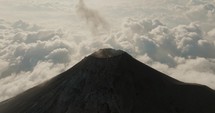Aerial view of Fuego volcano erupting ash above the clouds in Guatemala.	
