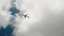 A View Of An Airplane Flying During Cloudy Day. Tracking Shot	