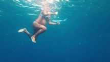 Pregnant woman swimming in the ocean. Pre-natal exercises