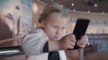 Little child is staring at smartphone screen