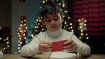 Young boy Preparing letter for Santa on his desk 
